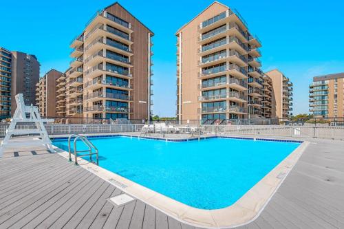 a swimming pool with two tall apartment buildings at Sea Colony - 55073 Pine Shore in Bethany Beach
