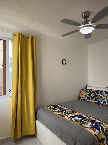 a bedroom with a bed and a ceiling fan at Modern Tropical Oasis in Sosúa