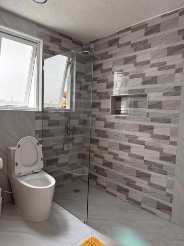 a bathroom with a toilet and a glass shower at Modern Tropical Oasis in Sosúa