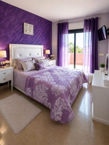a purple bedroom with a bed with a purple wall at Duquesa Coto Real in Manilva