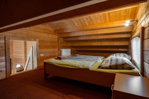 a bedroom with a bed in a wooden cabin at Waldsiedlung - Haus 10 in Großkoschen