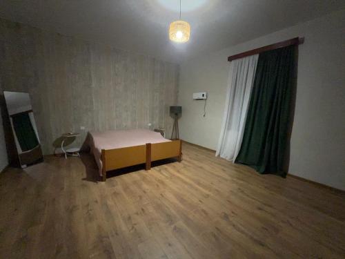 ein Zimmer mit einem Bett und einem großen Fenster in der Unterkunft Sameba House in Khuts'ubani