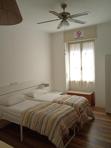 zwei Betten in einem Schlafzimmer mit Deckenventilator in der Unterkunft Cozy!! Verona in Verona