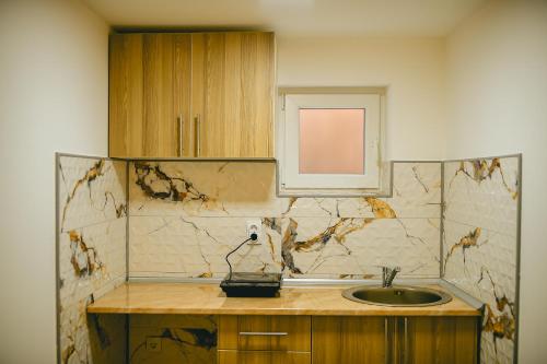 a bathroom with a sink and a window at Lux apartmani Savić in Aleksinac