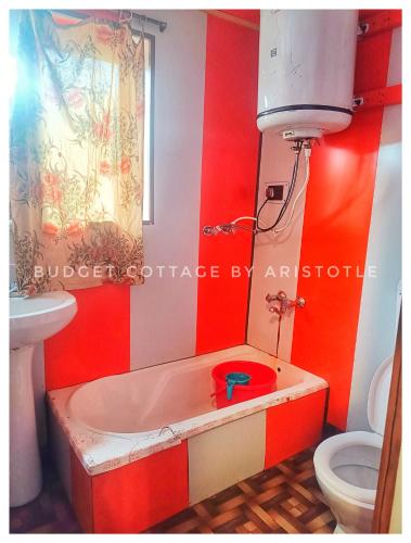 a bathroom with a tub with a sink and a toilet at Budget Cottage By Aristotle in Srinagar