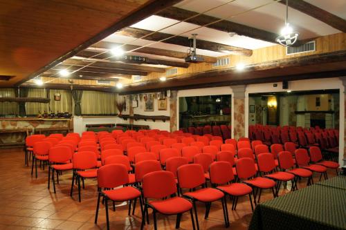 a large room with red chairs and tables in it at Hotel Milano in Asiago