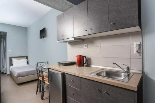 a kitchen with a sink and a bed in a room at Soluna Studios in Polychrono