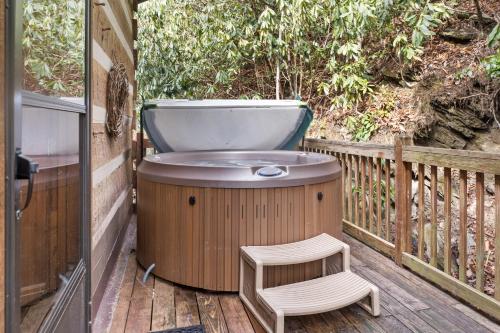a hot tub and a chair on a deck at Creekside Cabin in Blowing Rock
