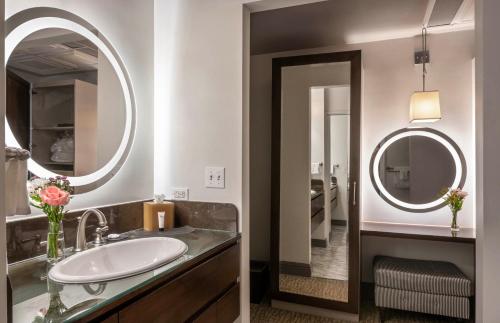 a bathroom with a sink and two mirrors at Warwick San Francisco in San Francisco