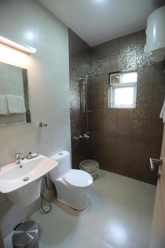 a bathroom with a toilet and a sink and a shower at Two Seas Residence - Boutique Residences in Ooty