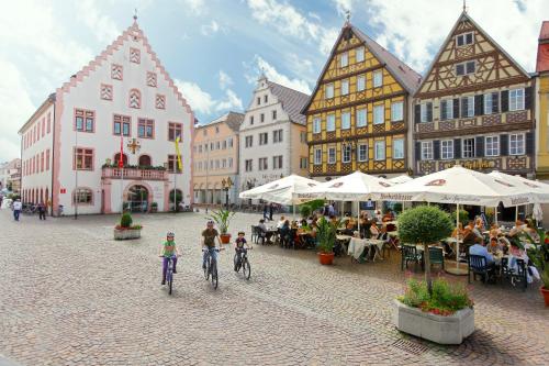 two people riding bikes down a street in a town at Best Western Premier Parkhotel Bad Mergentheim in Bad Mergentheim
