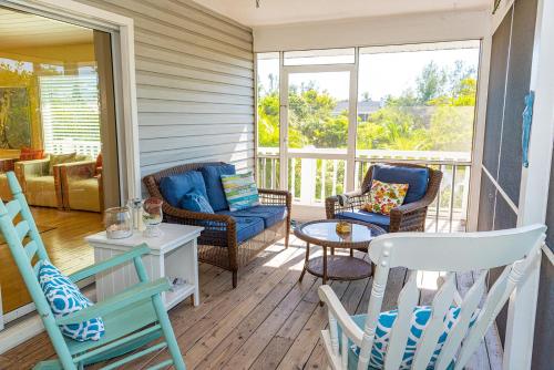 a screened in porch with chairs and a table at White Shell in Anna Maria