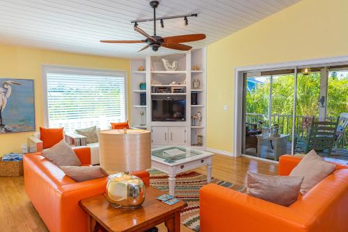 a living room with two orange couches and a table at White Shell in Anna Maria