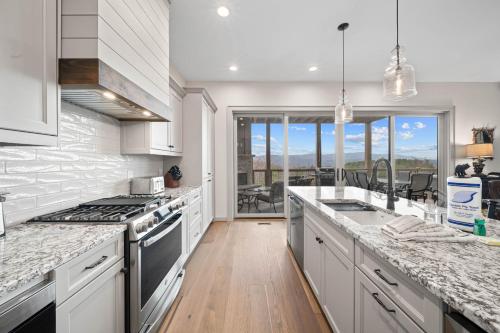 a kitchen with white cabinets and a view of a patio at Happy Campers in Boone