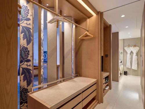a dressing room with wooden walls and a large mirror at Sofitel Mauritius L'Imperial Resort & Spa in Flic-en-Flac
