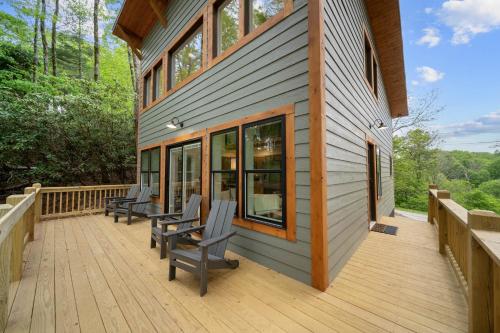 a wooden deck with chairs on the side of a house at Appalachian Cottage in Blowing Rock