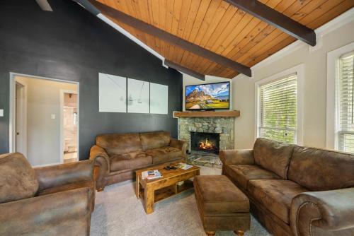 a living room with leather furniture and a fireplace at Treehouse On Beech in Beech Mountain