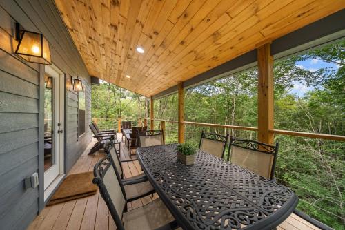 a screened in porch with a table and chairs at Pine Ridge Retreat in Beech Mountain