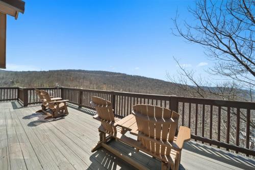 two wooden benches sitting on the deck of a house at Western Wonder in Beech Mountain