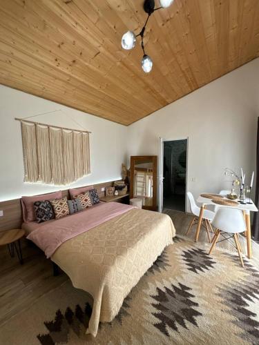 a bedroom with a large bed and a table at Cottage RoKSa 2 з басейном in Slavske