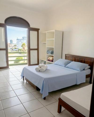 a bedroom with a bed with towels on it at Hotel D'Italia in Arroio do Sal