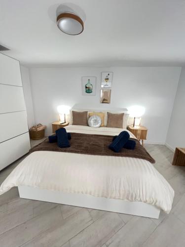 a white bedroom with a large bed with two blue pillows at Gratitud Un refugio con encanto in Soo