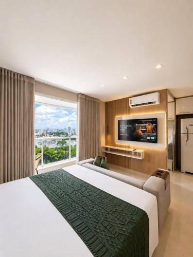 a hotel room with a large bed and a tv at The Expression Building - Setor Bueno - THP in Goiânia