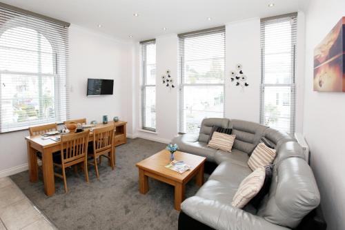 a living room with a couch and a table at Austens Apartments in Torquay