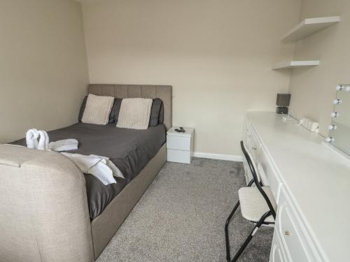 a small bedroom with a bed and a dresser at 9 Beckett Close in Colwyn Bay