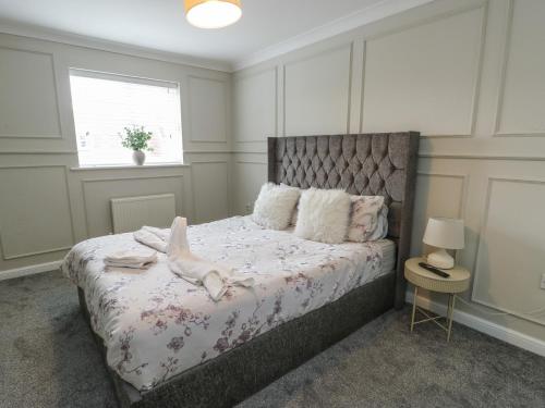 a bedroom with a bed with a dog on it at 9 Beckett Close in Colwyn Bay
