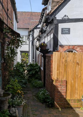 an alley in a house with a wooden fence at Magpie Cottage in Ledbury