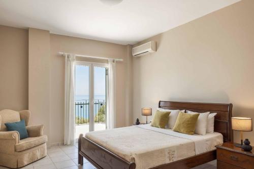 a bedroom with a bed and a chair and a window at Villa Mihas in Vlachata