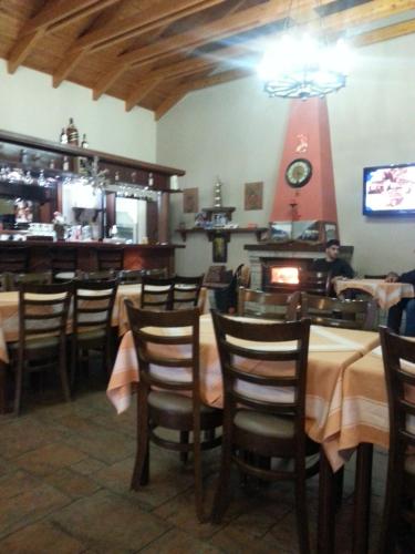 uma sala de jantar com mesas e cadeiras num restaurante em My Woodenfriend em Káto Khóvoli
