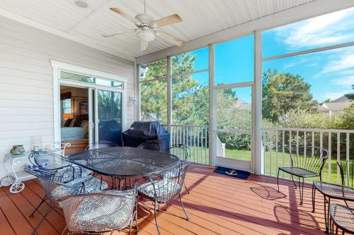 a room with a table and chairs on a porch at Bear Trap Dunes - 15 Sycamore in Ocean View