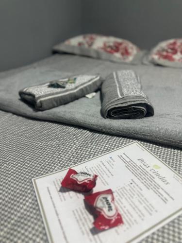 a bed with two towels and a piece of paper at Suite em Mulungu in Mulungu