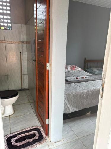 a bathroom with a toilet and a bed at Suite em Mulungu in Mulungu