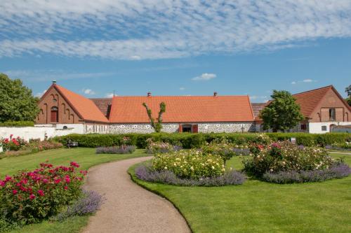 a garden with flowers and a building in the background at Guest apartment in the castle in Höör