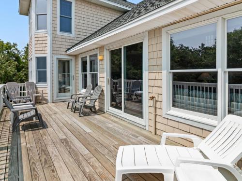 a deck with chairs and tables on a house at 4160 - Shipley in Kitty Hawk
