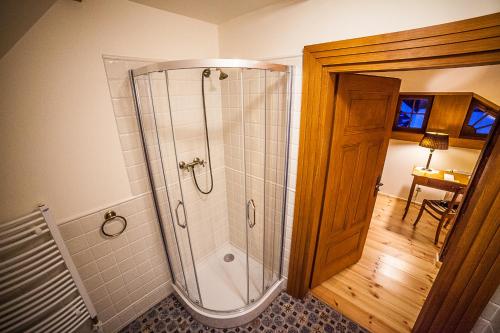 a shower with a glass door in a bathroom at Pensjonat Dom Zegarmistrza in Bogatynia