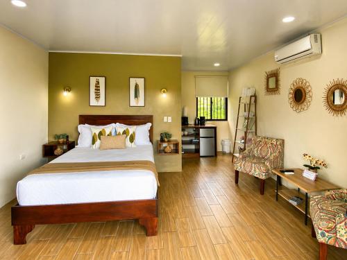 a bedroom with a bed and a desk and a chair at Buganvilia, Cabaña Privada con vista al Volcán Arenal in Palma