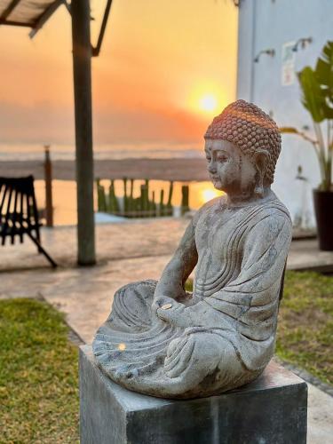 a statue of a woman sitting on the beach at Hotel Lunazul In Costa Esmeralda in La Vigueta