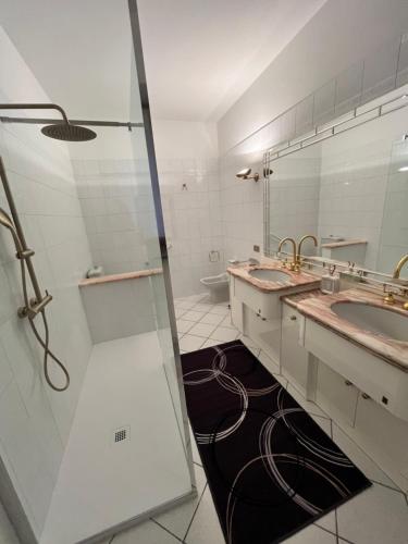 ein Badezimmer mit zwei Waschbecken und einer Dusche in der Unterkunft Giulia Cottage in Strona