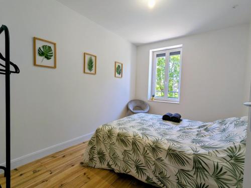 a bedroom with a bed and a window at Air-conditioned apartment - two bedrooms in Vichy