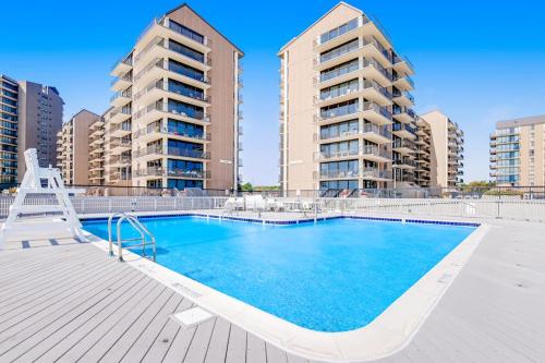 a swimming pool with two tall apartment buildings at Sea Colony - 1804 Doubles in Bethany Beach