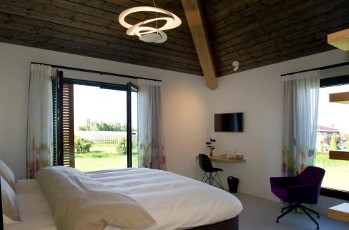 a bedroom with a large bed and a window at als het golft in Roelofarendsveen