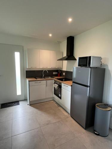 a kitchen with a refrigerator and a sink at Cottage with garden in La Roche-sur-Yon