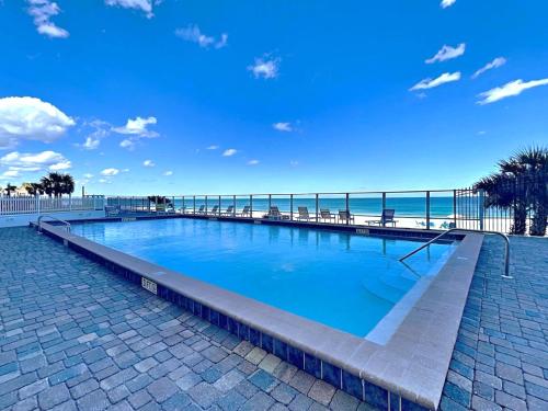 a swimming pool with the beach in the background at Oceanside Retreat 804 in Ormond Beach