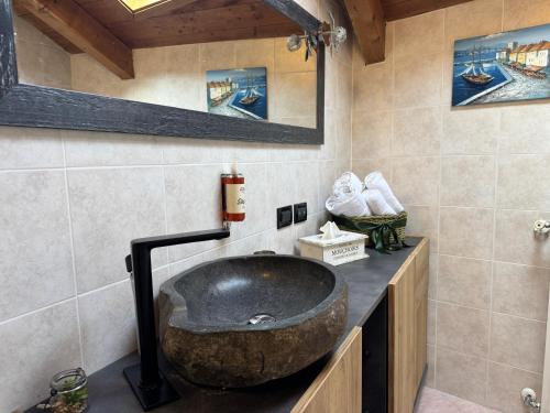 a bathroom with a large rock sink on a counter at Il Torchio - Guest House Lago Maggiore in Dormelletto