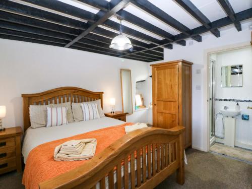 a bedroom with a large bed and a bathroom at Farm Cottage in Cemaes Bay