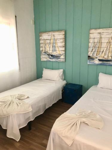 two beds in a room with a boat on the wall at Vilasardemarlux1 in Vilassar de Mar